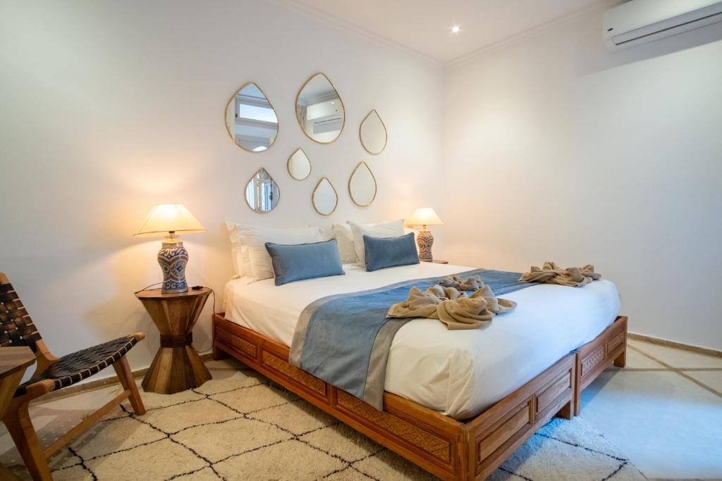 une chambre avec un lit et des miroirs au mur dans l'établissement Riad Bibazia, à Marrakech