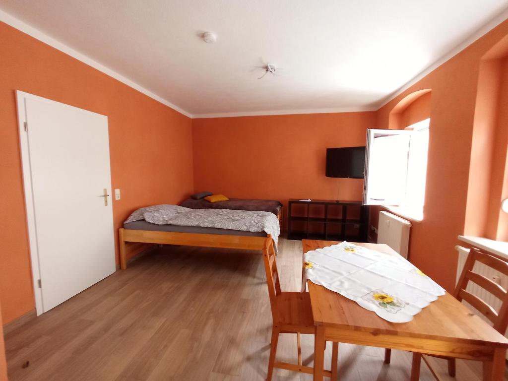 um pequeno quarto com uma cama e uma mesa em kleine 1-Raum-Ferienwohnung mit hohem Komfort em Teuchern