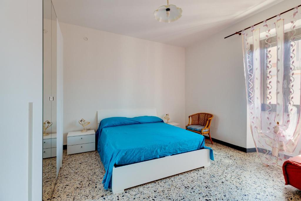 una camera bianca con un letto con una coperta blu di Casa vacanze Ghilarza Sardegna a Ghilarza