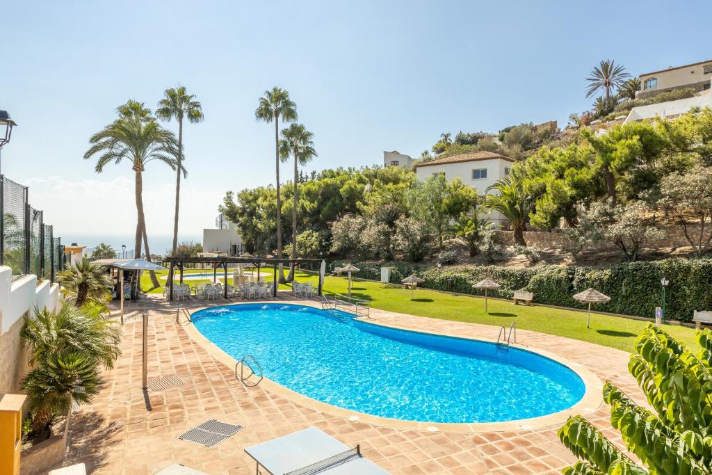uma piscina num resort com palmeiras em Villa Sol de la Molina em Salobreña