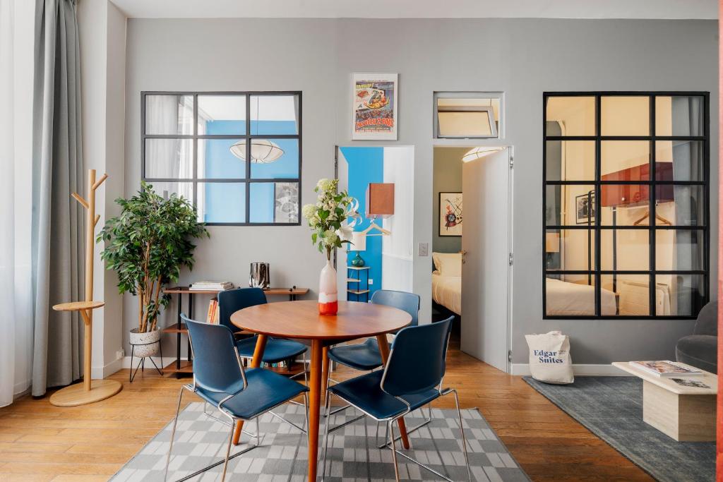 un salon avec une table et des chaises bleues dans l'établissement Balyam Suites Montorgueil - Sentier, à Paris