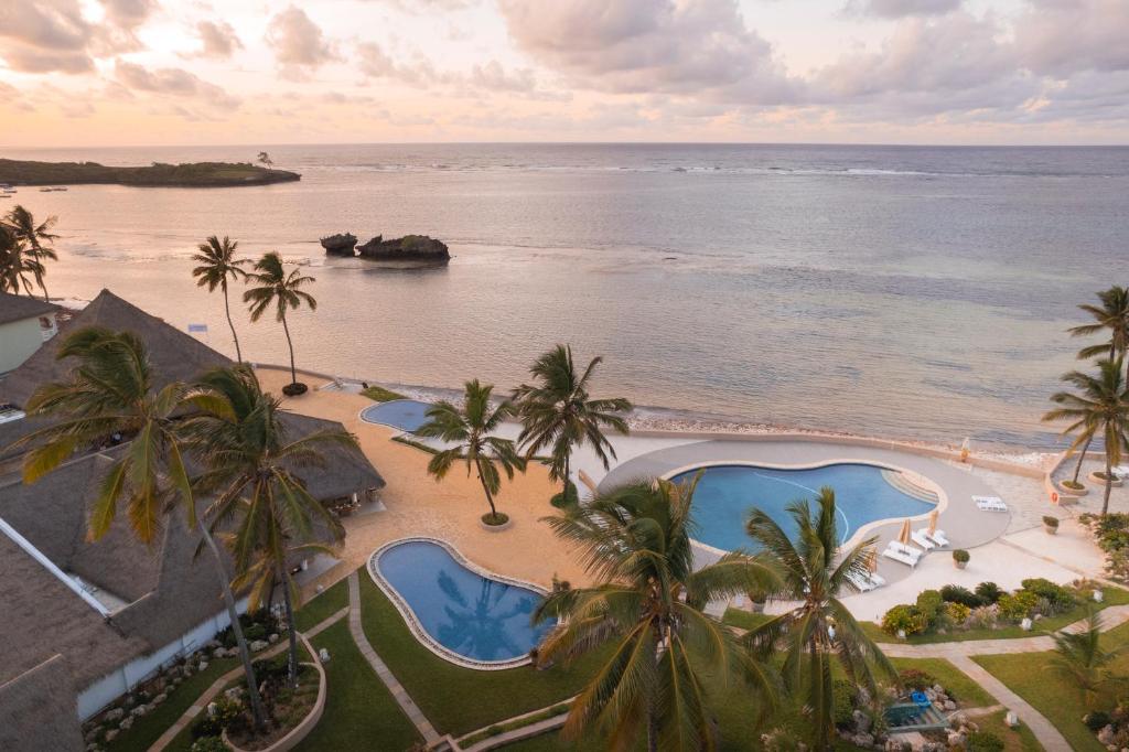 uma vista aérea de um resort com palmeiras e o oceano em Hemingways Watamu em Watamu