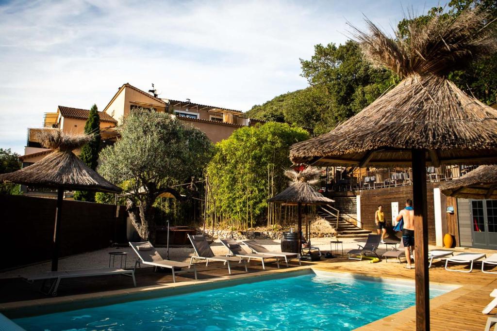 a swimming pool with chairs and umbrellas at Le Belvedere in Vallon-Pont-dʼArc