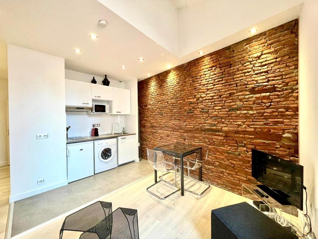 a brick wall in a living room with a fireplace at Le Caboteur - Studio proche Place de la Daurade in Toulouse