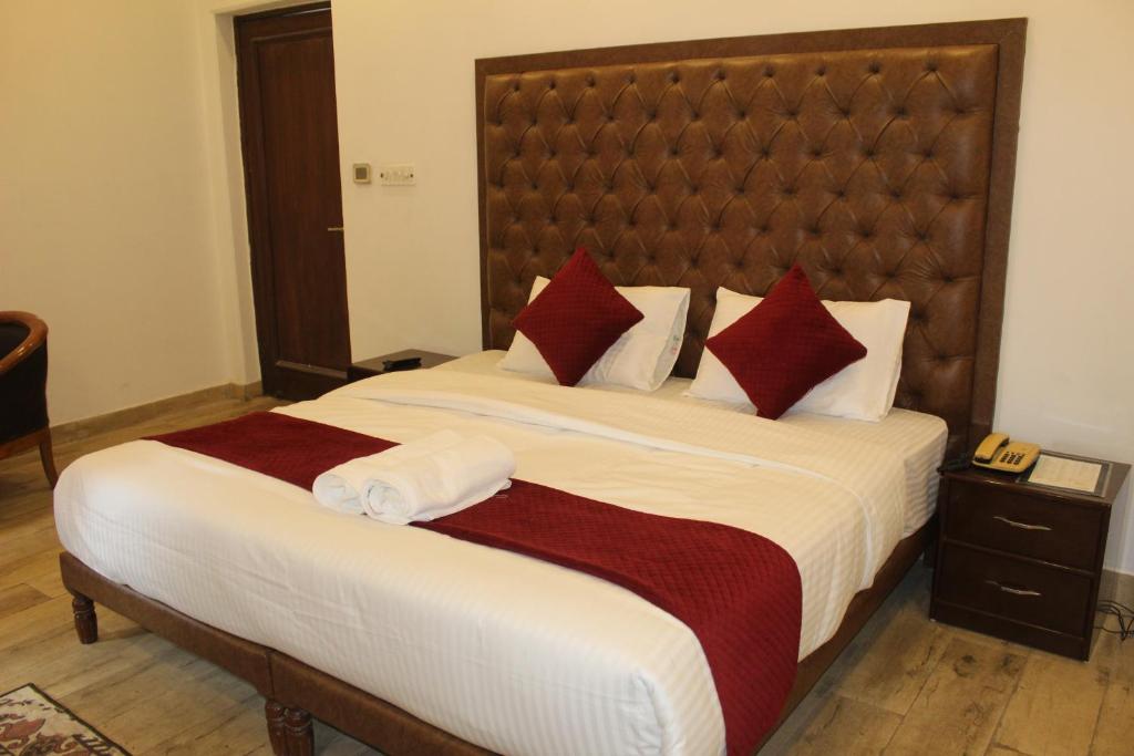 ein Schlafzimmer mit einem großen Bett mit roten und weißen Kissen in der Unterkunft Khanna Residency in Neu-Delhi