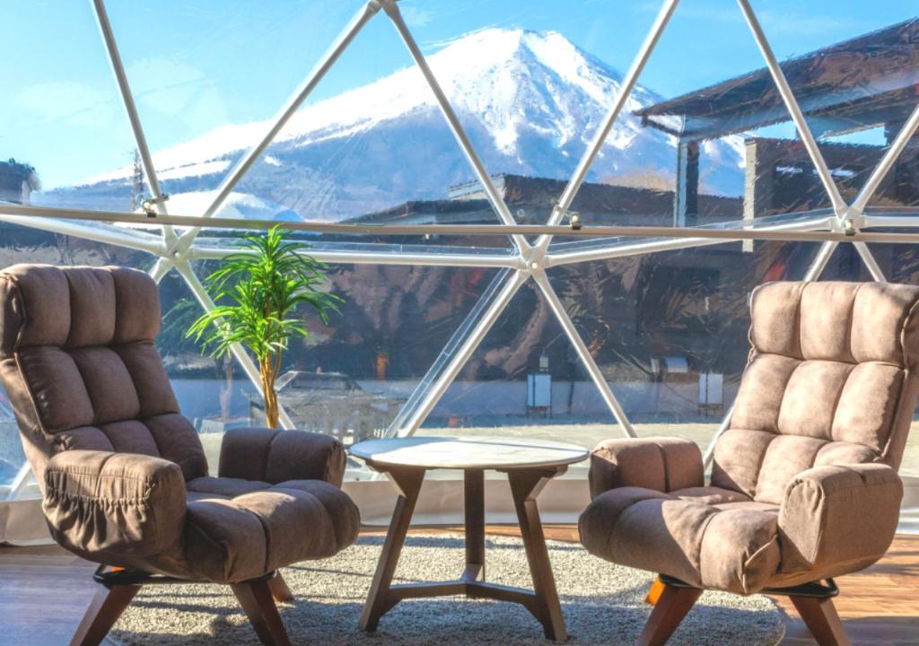 山中湖的住宿－VISION GLAMPING Resort & Spa 山中湖 ビジョングランピングリゾート山中湖，窗前的两把椅子和一张桌子