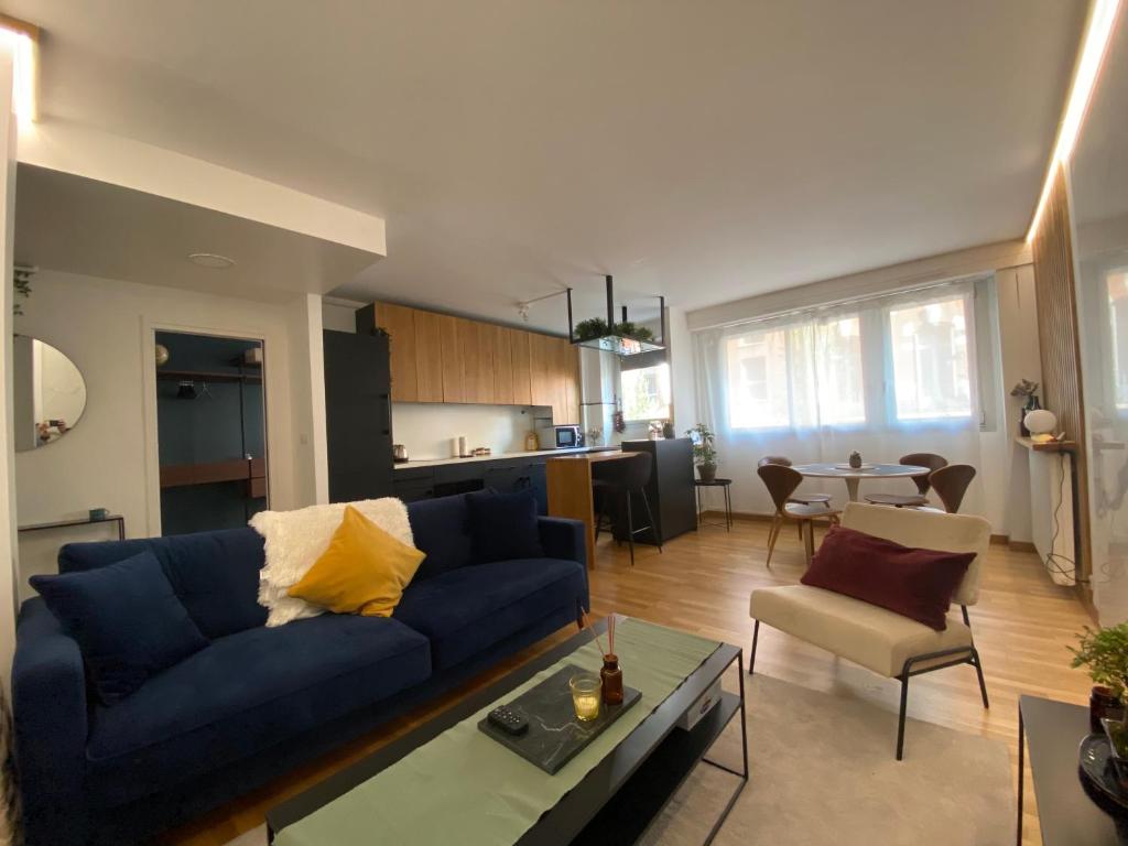 un salon avec un canapé bleu et une table dans l'établissement L'Eclatant - Au cœur de Toulouse, à Toulouse