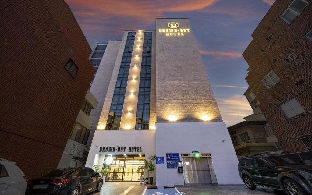 un bâtiment avec une voiture garée devant lui dans l'établissement Brown Dot Hotel Sajik Baseball Stadium, à Busan