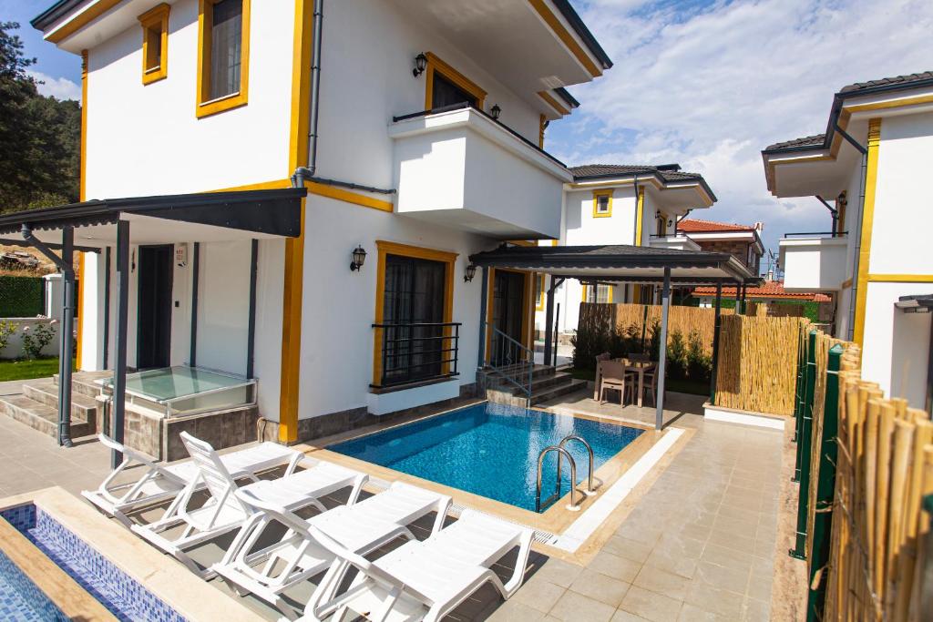 uma villa com uma piscina e uma casa em Yellow Villa em Muğla