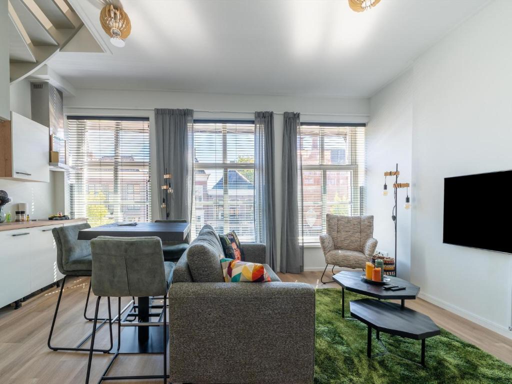 een woonkamer met een bank en een tafel bij Modern renovated apartment in the heart of Sneek in Sneek