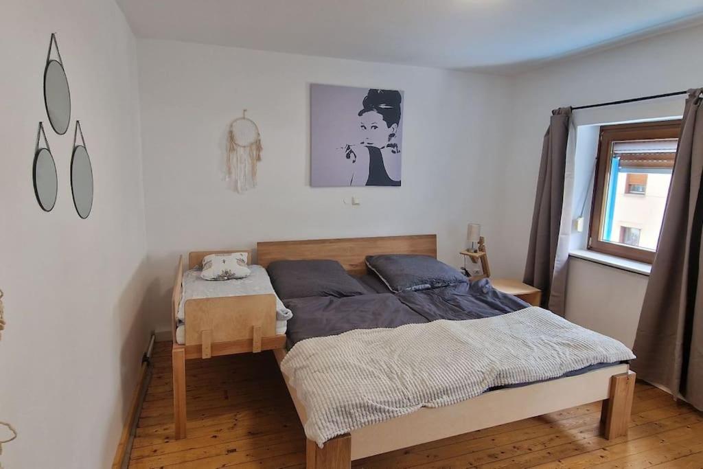 ein Schlafzimmer mit einem Bett in einem weißen Zimmer in der Unterkunft Wohnwerk: Das Moselhaus, direkt Grenze Luxemburg in Oberbillig