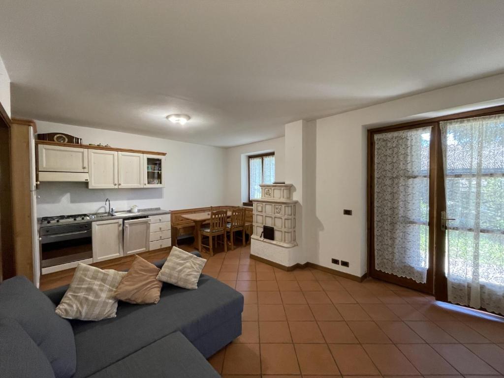 a living room with a blue couch and a kitchen at Appartamenti Castagner in Pinzolo