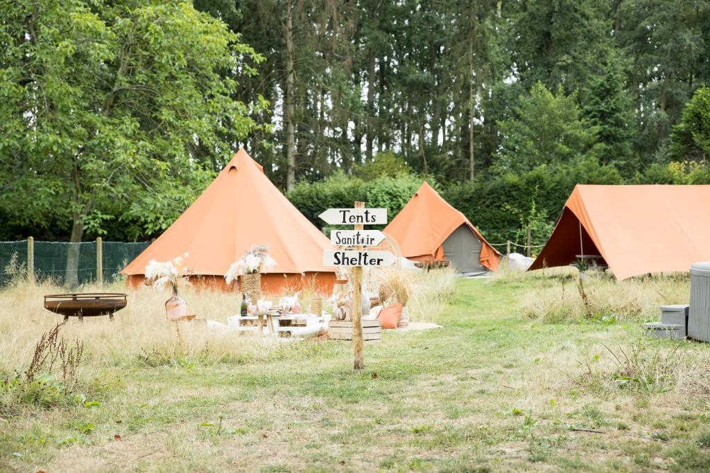 a group of tents with a sign in the grass at Fiertelmeers Boutique Glamping in Ronse