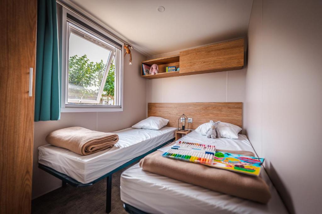 Postel nebo postele na pokoji v ubytování Camping le Roucan West