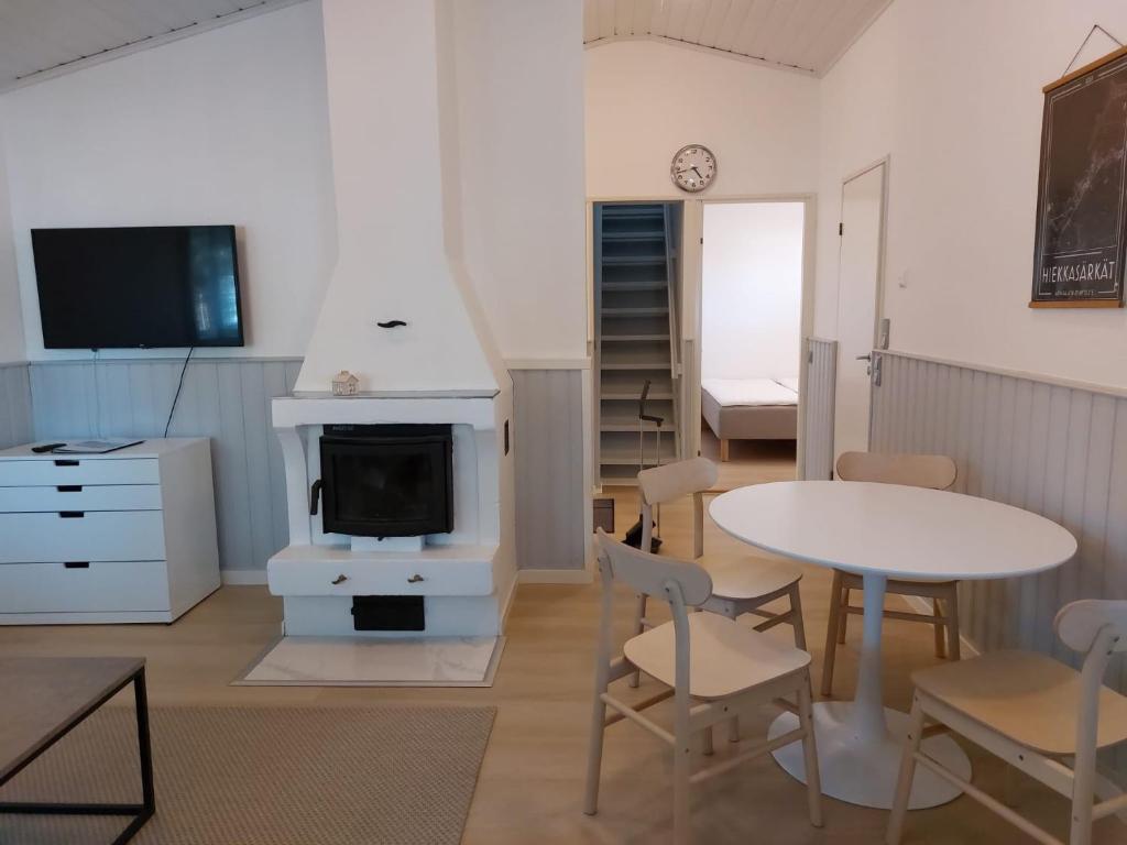 ein Wohnzimmer mit einem Tisch und einem Kamin in der Unterkunft Merimaisema 6 in Kalajoki