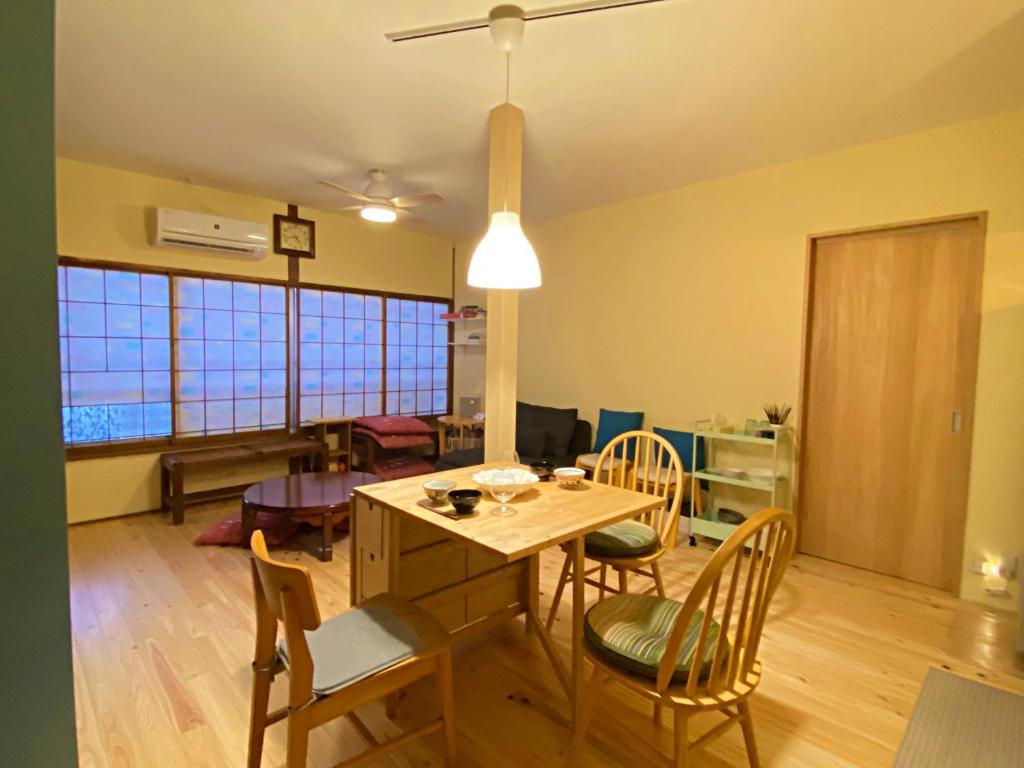 uma sala de estar com uma mesa de jantar e cadeiras em Guesthouse Imaichi ゲストハウス今市マチナカ em Nikko