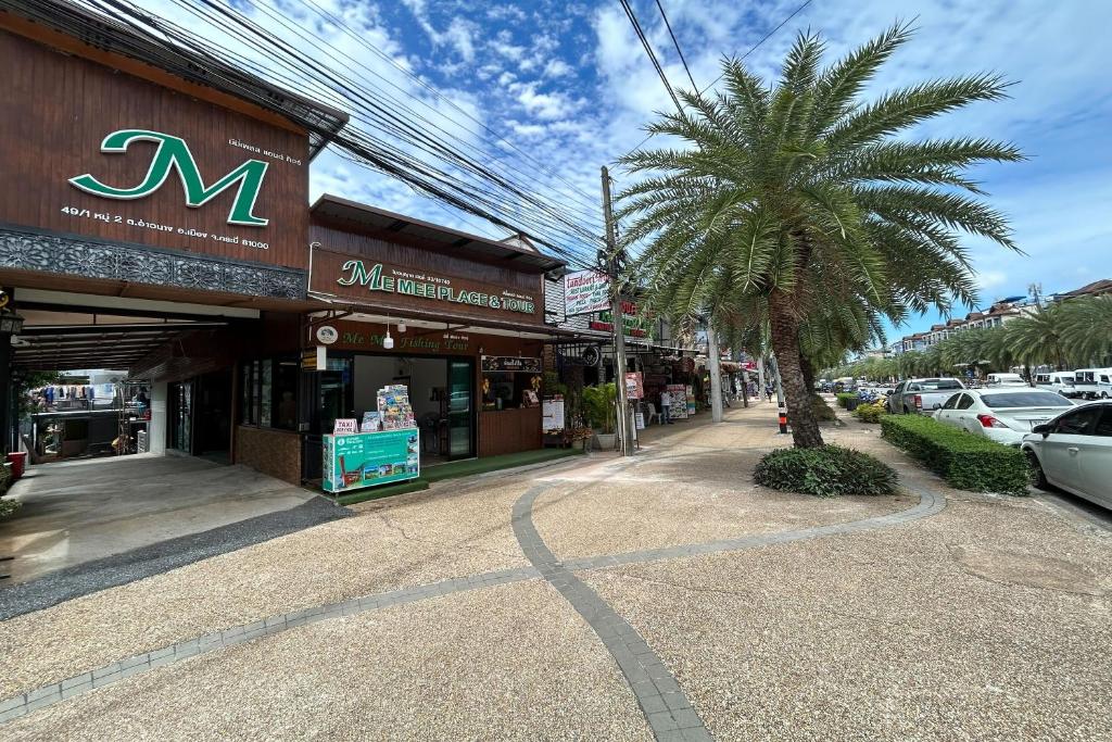 uma rua com uma palmeira em frente a uma loja em Me Mee Place & Tour Krabi em Praia de Aonang