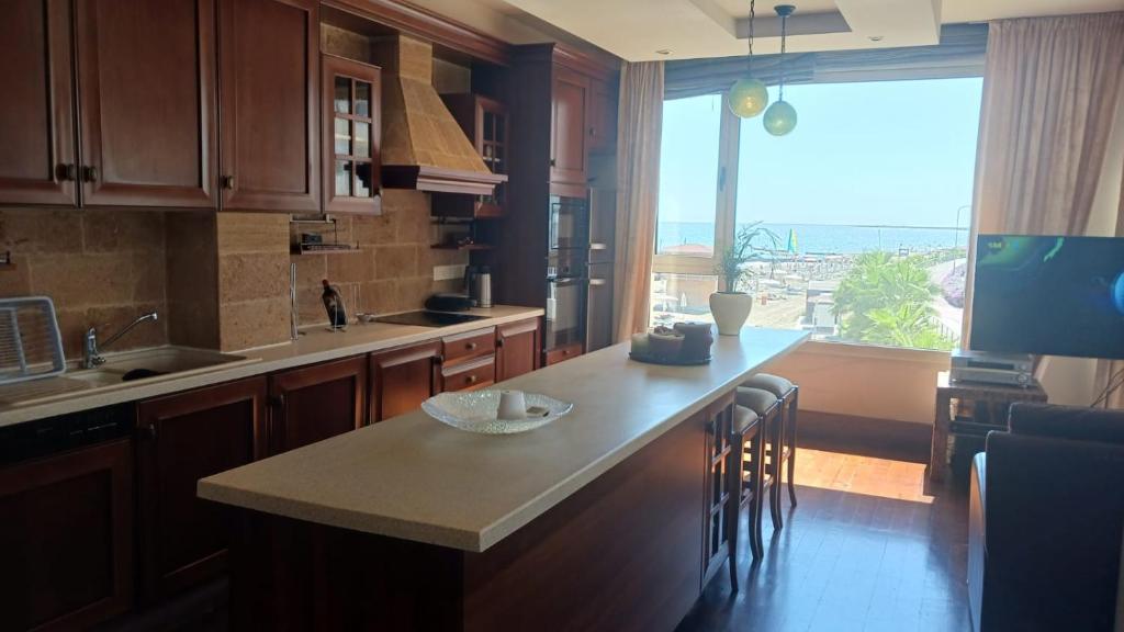 cocina con encimera y ventana grande en Quattro Sea View Beachfront Ap 6, en Lárnaca