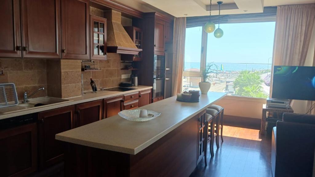 a kitchen with a counter and a large window at Quattro Sea View Beachfront Ap 6 in Larnaca