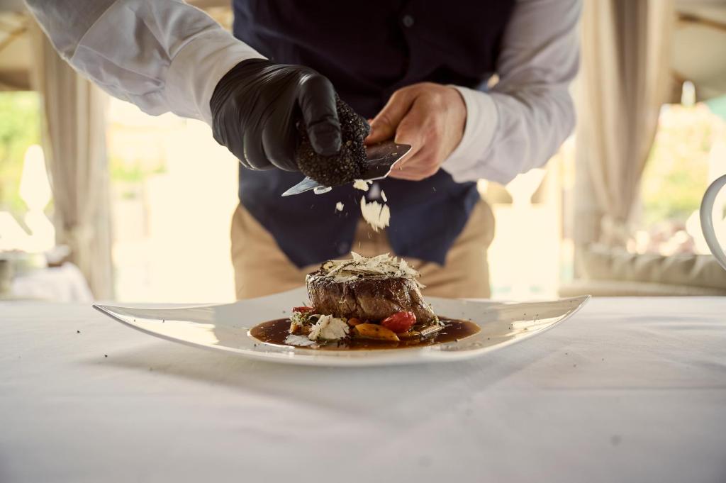 a chef is eating a dessert on a plate at Grand Hotel Imperiale in Forte dei Marmi