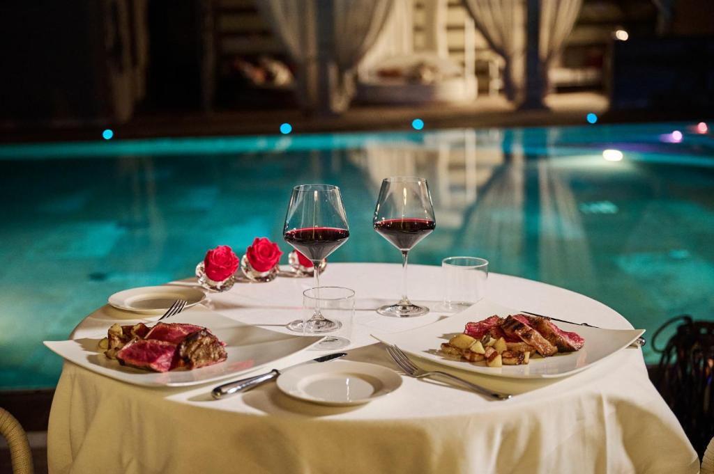 a table with two glasses of wine and food on it at Grand Hotel Imperiale in Forte dei Marmi