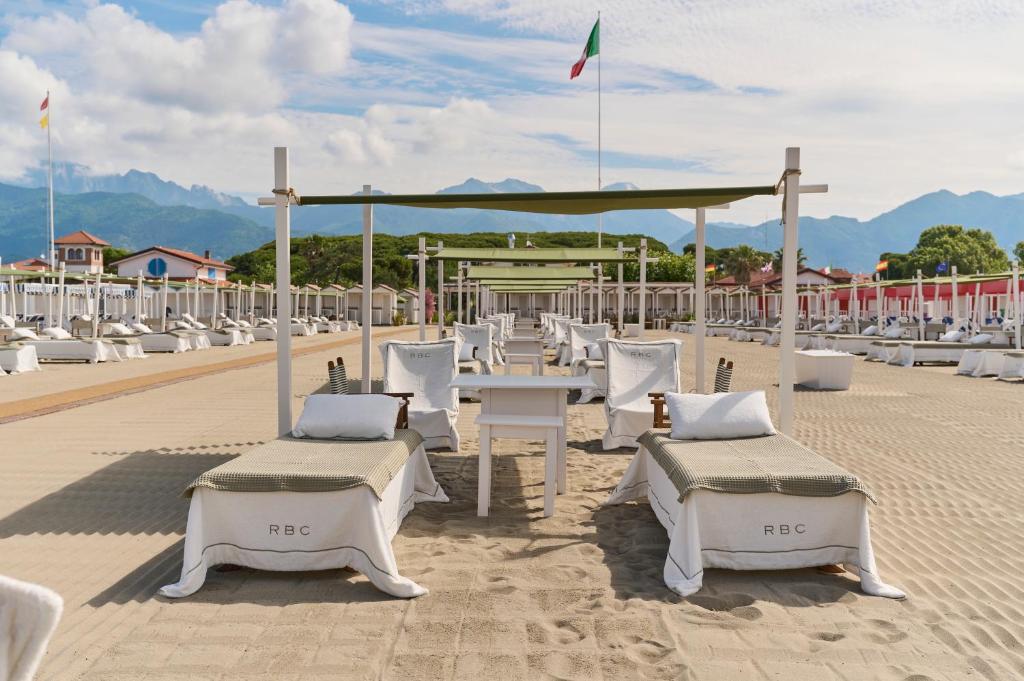 a group of tables and chairs on a beach at Grand Hotel Imperiale in Forte dei Marmi