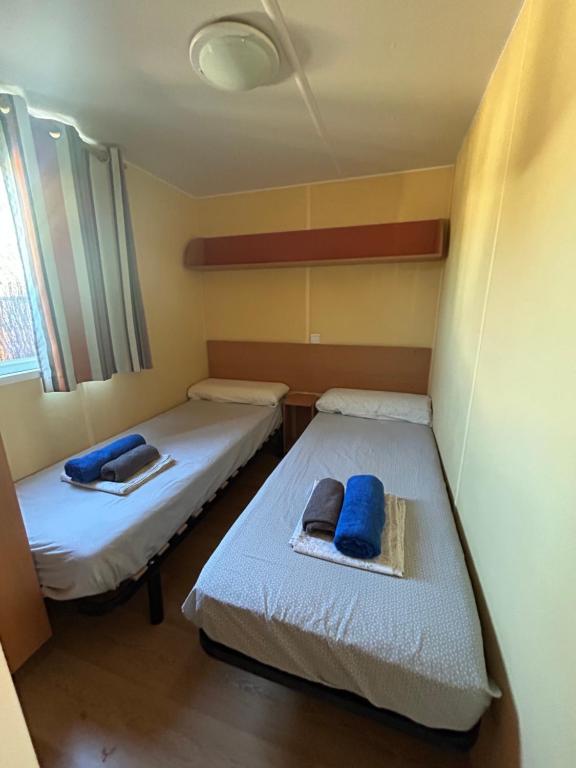 2 bedden in een kleine kamer met blauwe kussens bij LA ALMADRABA del Palmar de Vejer I in Cádiz