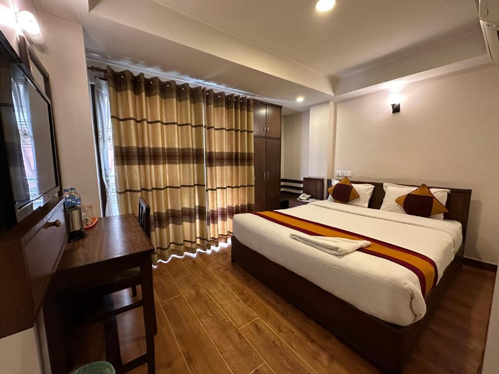 een hotelkamer met een groot bed en een bureau bij Hotel Everest Nepal in Kathmandu