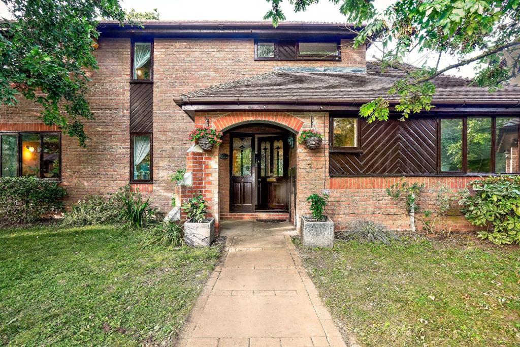 a brick house with a door and a sidewalk at Spring Close in Colchester