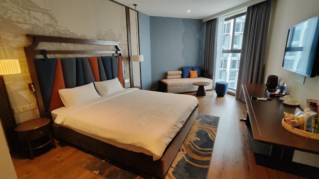 una camera d'albergo con un grande letto e una scrivania di Apec Mandala Wyndham Phan Thiet - Mui Ne a Ấp Thiẹn Ái