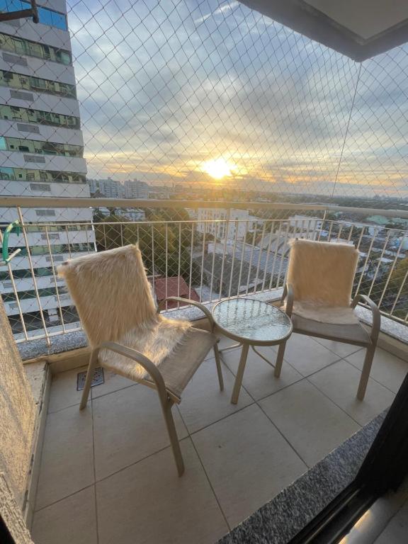 zwei Stühle und ein Tisch auf einem Balkon mit Aussicht in der Unterkunft Apto COND PRIVATIVO piscina, academia e garagem in Porto Alegre