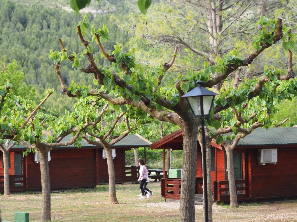 a person walking in front of a building with trees at Moli l&#39;Abad in Puebla de Benifasar