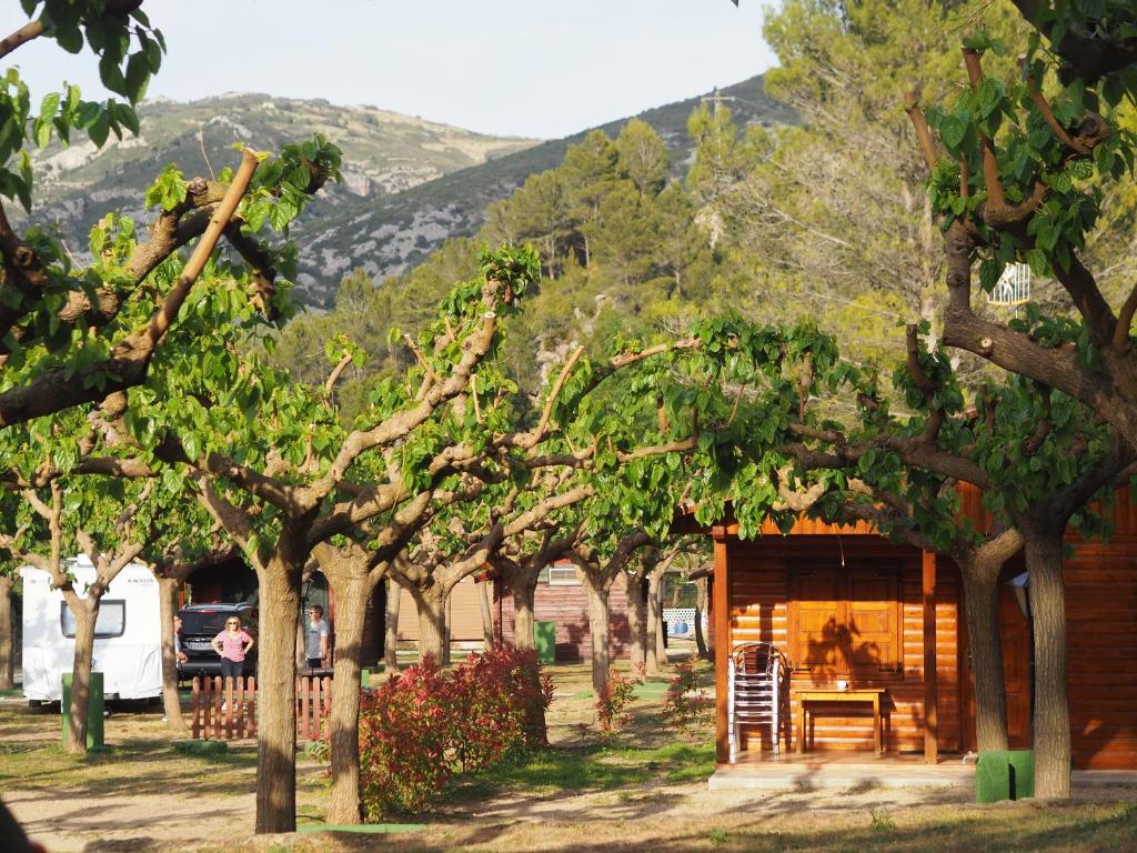 a log cabin with a table and chairs in the trees at Moli l&#39;Abad in Puebla de Benifasar