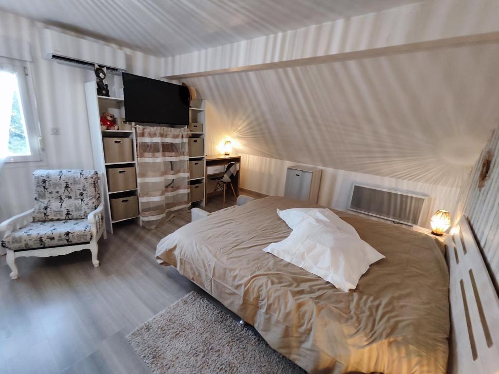 ein Schlafzimmer mit einem großen Bett und einem Stuhl in der Unterkunft Au Ch'ti Suisse 