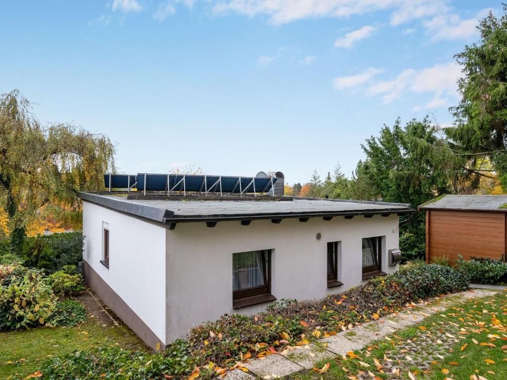 Holiday home in Langscheid with panoramic view في Langscheid: منزل على السطح مع لوحات شمسية