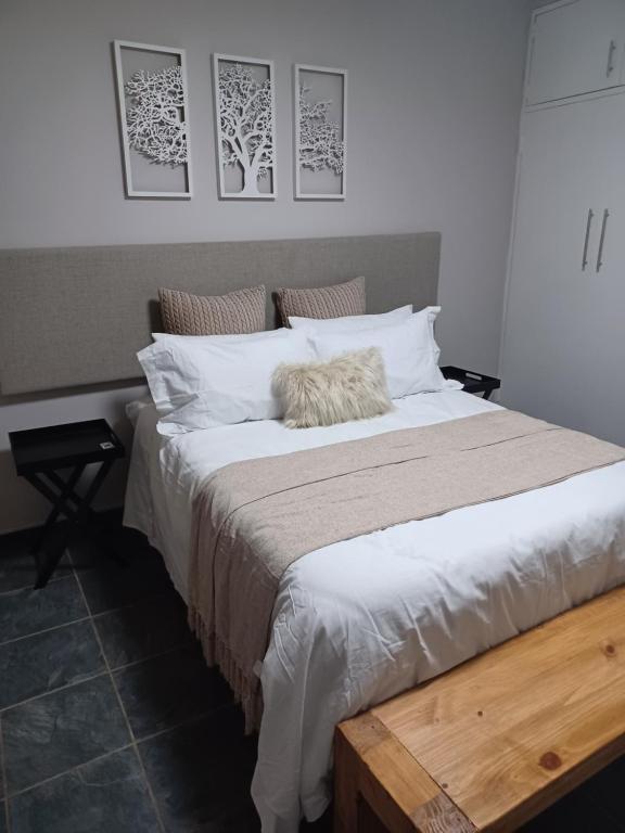 金伯利11 Debonair Self Catering Apartment的卧室里有一张铺着白色床单的大床