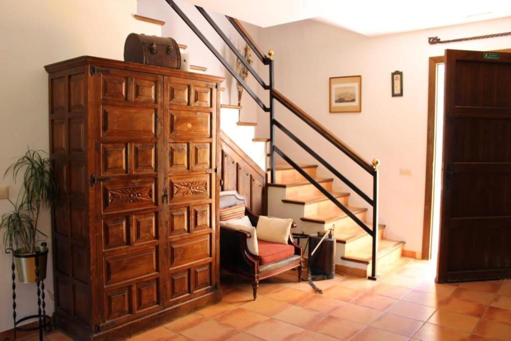 sala de estar con escalera y armario de madera en Casa La Camorra, en Teba