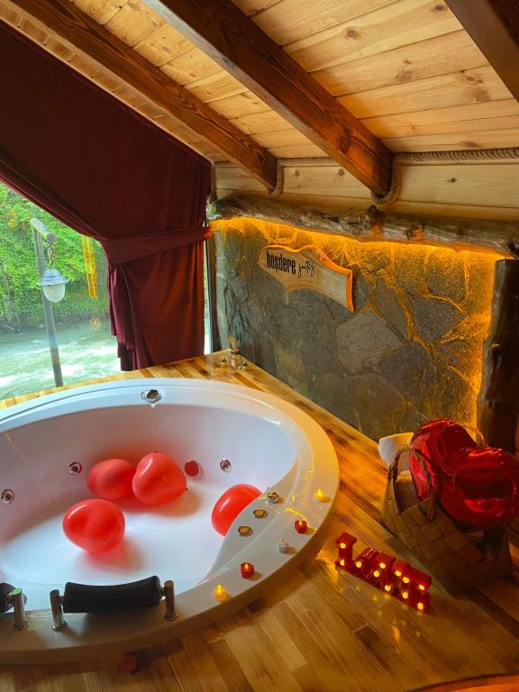 Çamlıhemşin的住宿－Hoşdere Suit，浴缸在红色西红柿的房间
