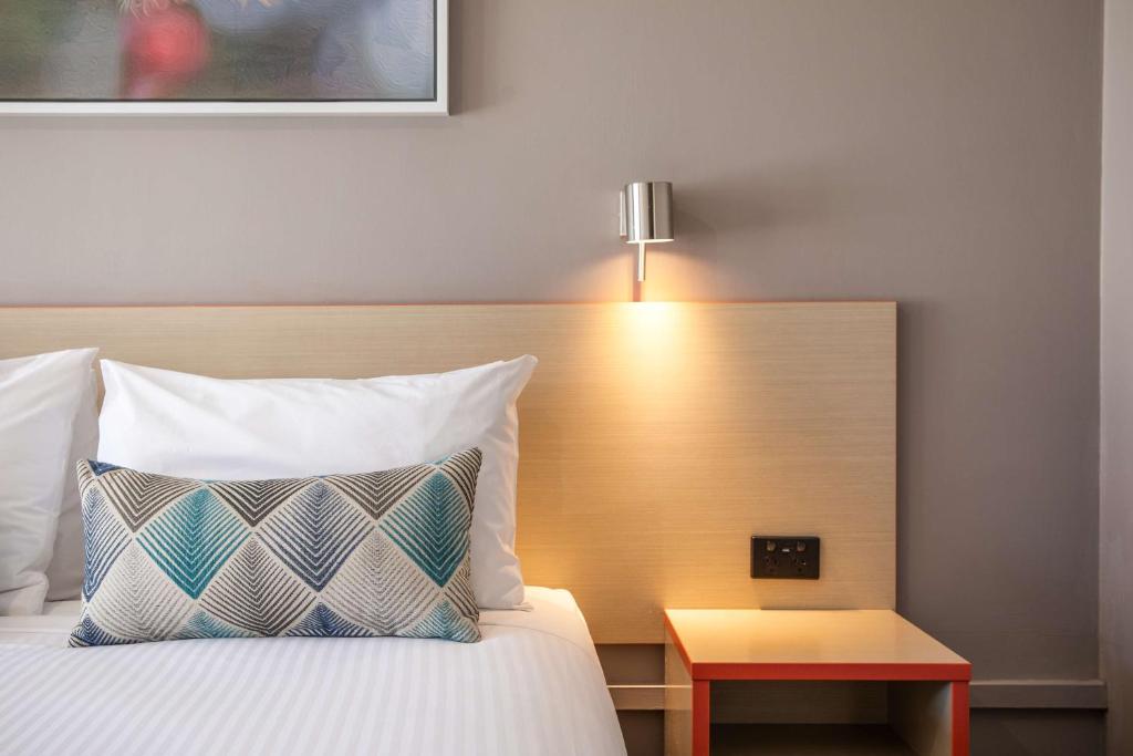 Pokój hotelowy z łóżkiem z lampką i stołem w obiekcie Nightcap at Ferntree Gully Hotel Motel w mieście Fern Tree Gully