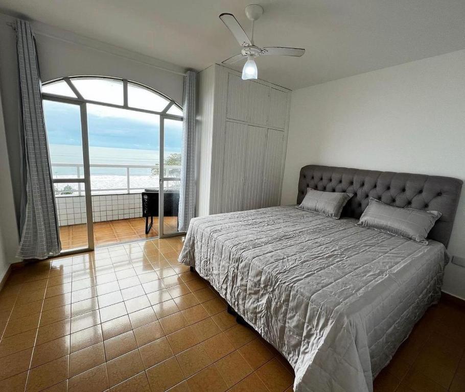 1 dormitorio con cama grande y ventana grande en Ap401 Praia do morro, en Guarapari