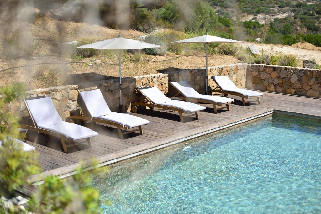 - un groupe de chaises longues et de parasols à côté de la piscine dans l'établissement Villa Bergeries De Calvi, à Calvi