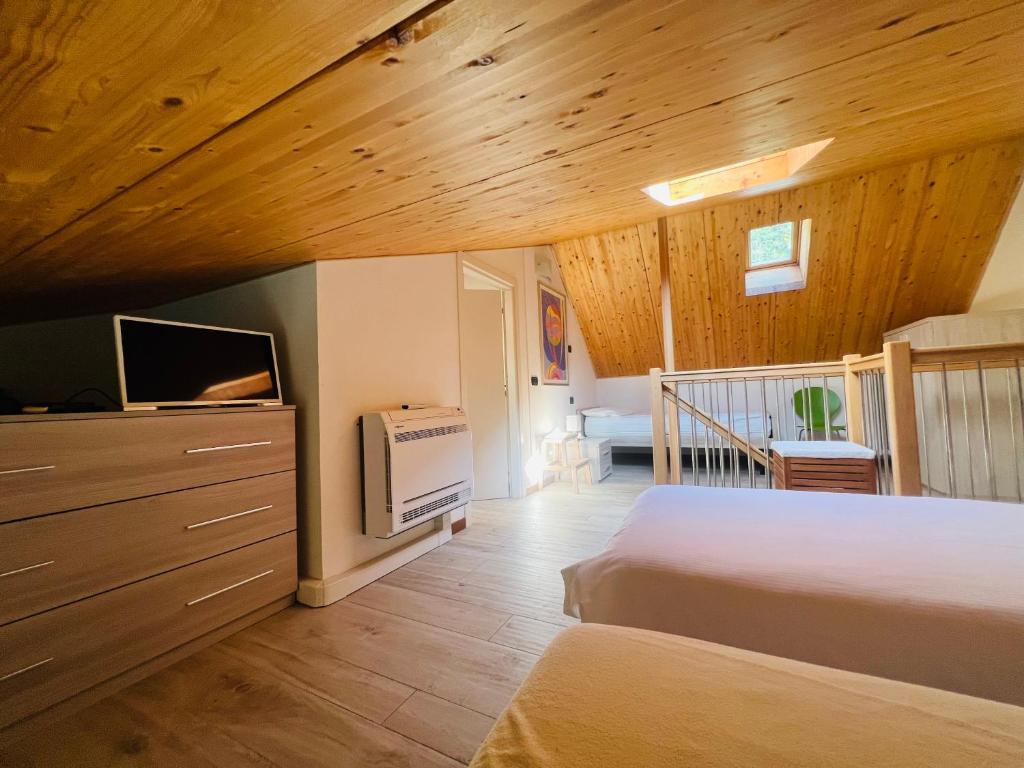 - une chambre avec un lit, une télévision et des plafonds en bois dans l'établissement Bellavista Giulia on Lake Como, à Dervio