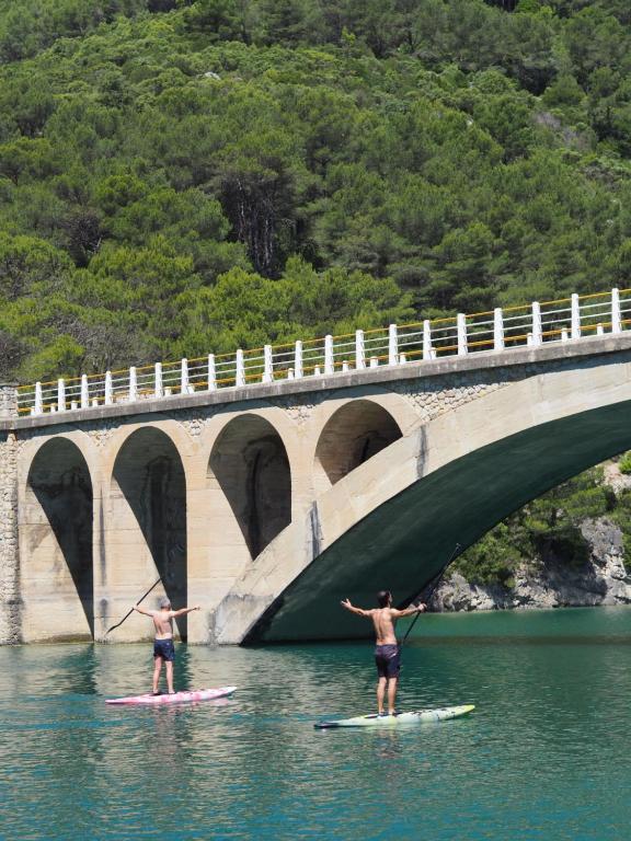 two people on surfboards in the water under a bridge at Moli l&#39;Abad in Puebla de Benifasar