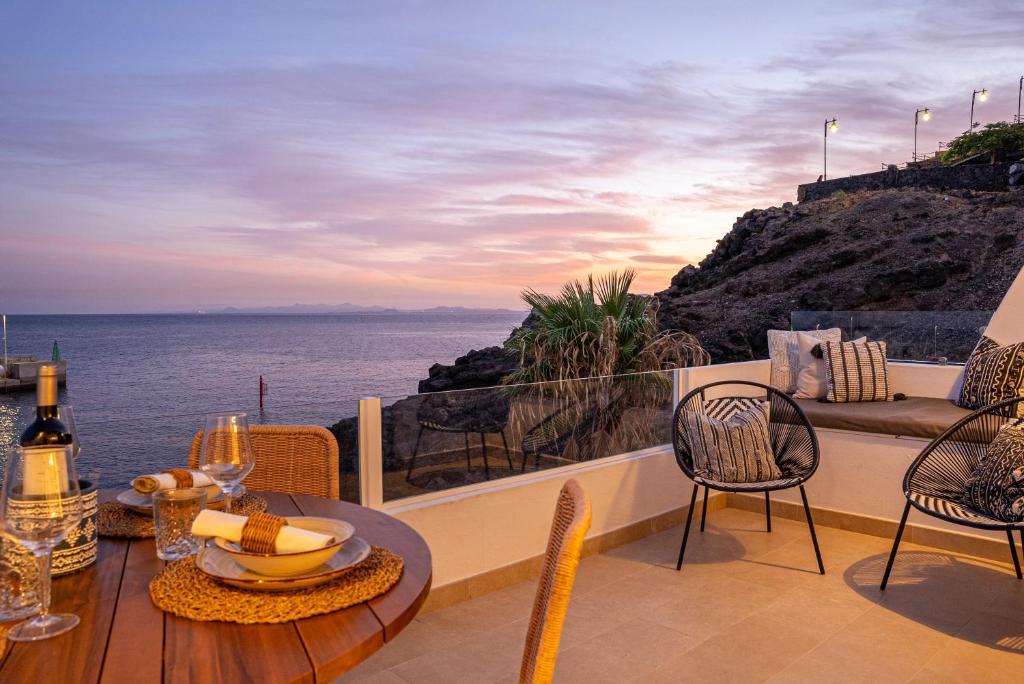 una mesa y sillas en un balcón con vistas al océano en Casa Galana, en Tías