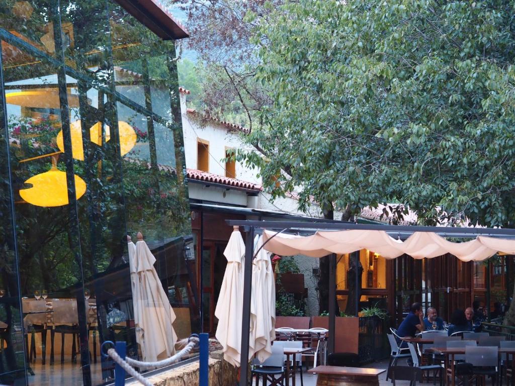 a patio with tables and umbrellas in a restaurant at Moli l&#39;Abad in Puebla de Benifasar