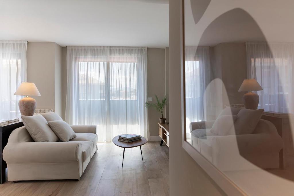 - un salon avec un canapé blanc et une table dans l'établissement Apartamentos Plaza Center, à Suances