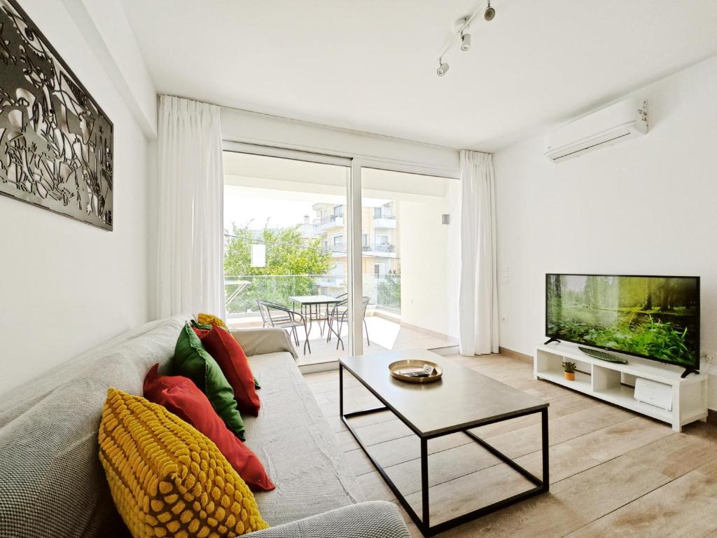 a living room with a couch and a tv at Marathonomachon Apartments by Verde Apartments in Athens
