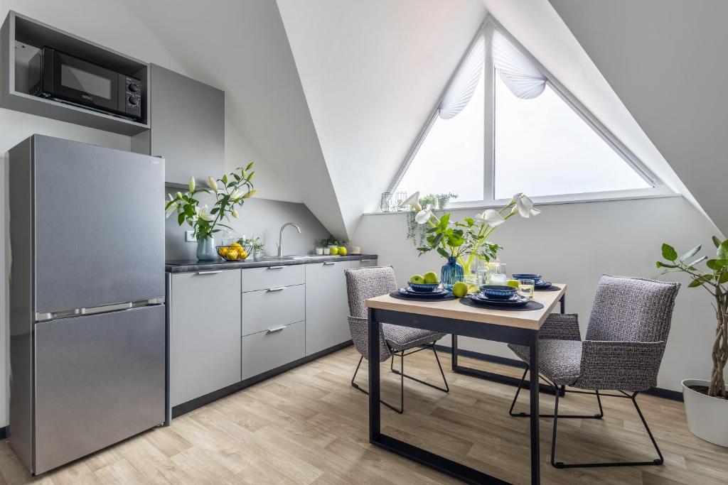 a kitchen with a table and a refrigerator at Aparthotel Solskiego Wrocław in Wrocław