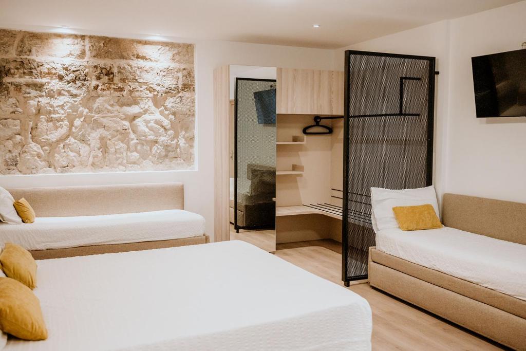トレントにあるHotel Veneziaのベッド2台とソファが備わる客室です。