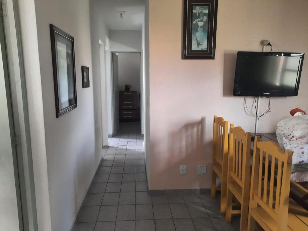 um corredor com uma sala de jantar e uma televisão na parede em Apartamento em Jacaraipe ES 3 quartos em Jacaraípe